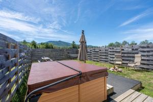 a patio with an umbrella and a table at Cheerful Cottage Close to Franconia Notch #4 in Carroll