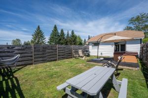 a backyard with a picnic table and an umbrella at Cheerful Cottage Close to Franconia Notch #4 in Carroll