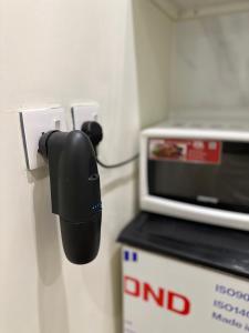 a black phone on a wall next to a microwave at Studio with smart entry in Riyadh