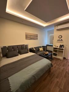 a bedroom with a large bed and a couch at Studio with smart entry in Riyadh
