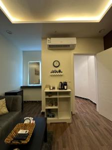 a living room with a couch and a clock on the wall at Studio with smart entry in Riyadh