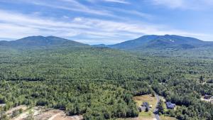 an aerial view of a forest with mountains in the background at Hike the Presidential's & Relax in the Hot tub #6 in Carroll