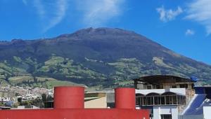 a mountain in the distance with a red building and a mountain at Hotel continental del sur in Pasto