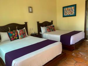 two beds in a hotel room with two beds sidx sidx sidx at Hacienda Santa Ireme in Zapotlanejo