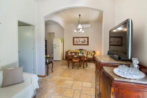 a living room with a couch and a dining room at The Old One by All About Paxos in Kourtaíïka +11 photos