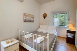 a white crib in a room with a window at The Old One by All About Paxos in Kourtaíïka
