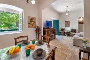 a living room with a table with fruit on it at The Old One by All About Paxos in Kourtaíïka