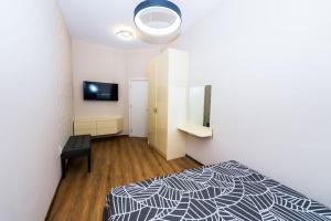 a bedroom with a black and white bed and a television at Flora Apartment in Burgas City