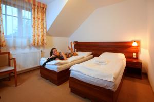 una mujer acostada en una cama en una habitación de hotel en Hostinec U Hubálků, en Kostelec nad Orlicí