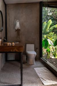 a bathroom with a toilet and a table and a window at El Indio EcoLodge in El Amparo