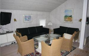 a living room with a couch and a table and chairs at Holiday Home Kamillevej Tranekær X in Skattebølle