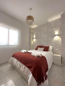 a bedroom with a large bed with a red blanket at KALUKA Málaga center apartment - free parking in Málaga