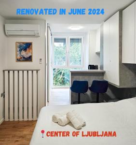 a room with a bed and two blue chairs at TOP - Ljubljana's Central Gem - free public parking in Ljubljana