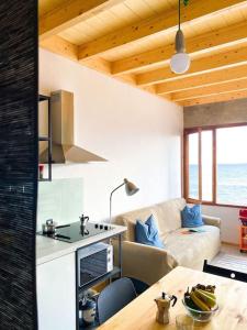a kitchen and living room with a couch and a table at CA'MALÚ Estudio en el mar in Arrieta +21 photos