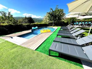 a swimming pool with lounge chairs and an umbrella at Gan Eden B&B in Monterenzio