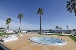 a large pool with palm trees and a fountain at Ocean View by Mar Holidays in Arenales del Sol