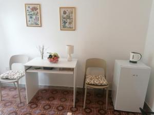 a white table and chairs in a room at B&B Villa Machi in Paola