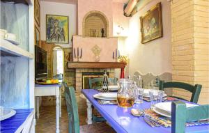 a dining room with a blue table and a fireplace at Awesome Apartment In Chianni With Wifi in Chianni