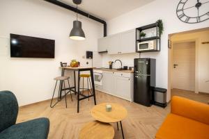 a kitchen and living room with a refrigerator and a table at Relaxing Holiday Apartment in Kornić