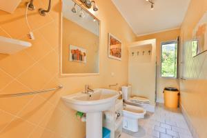 a bathroom with a sink and a toilet at Villino Lampone - Goelba in Lacona +9 photos