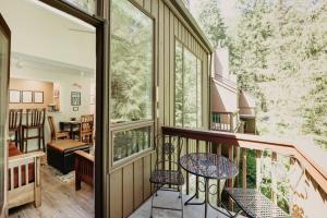 ein Balkon eines Hauses mit einem Tisch und Stühlen in der Unterkunft 82SW - Fireplace - WithD - Kitchen - Sleeps 4 condo in Glacier