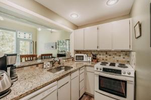 eine Küche mit weißen Schränken und einem Herd mit Backofen in der Unterkunft 82SW - Fireplace - WithD - Kitchen - Sleeps 4 condo in Glacier