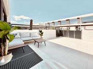 a patio with a couch and a table on a building at Casa Natura Arena Beach in Puerto Marino