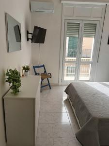 a bedroom with a bed and a desk and a tv at Diana's home in Avola