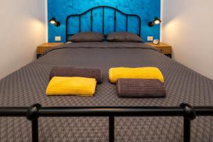 a bed with yellow and brown pillows on it at Relaxing Holiday Apartment in Kornić