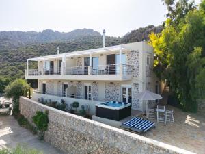 a large white house with a swimming pool and an umbrella at Mountain Villa Panorama in Stavrokhórion +9 photos