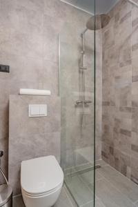 a bathroom with a toilet and a glass shower at Hotel AQUILO in Petrovac na Moru