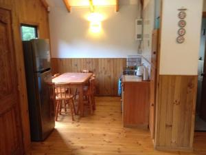 a kitchen with a table and a refrigerator at Cabaña grande en Malalcahuello in Malalcahuello +6 photos
