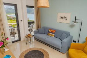 a living room with a blue couch and a balcony at Hotel AQUILO in Petrovac na Moru