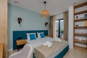 a bedroom with a large bed with a blue headboard at Hotel AQUILO in Petrovac na Moru +37 photos