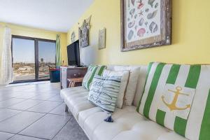 a living room with a white couch and a tv at Family Tides-The Ultimate Family Beachfront Condo! in Fort Walton Beach