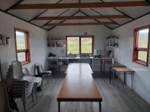 a kitchen with wooden tables and chairs in a room at Fremstaver in Blaskogabyggo