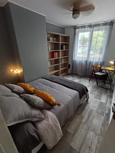 Maison Magnolia في Marcorignan: غرفة نوم بها سرير مع وسائد ونافذة