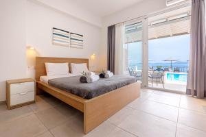a bedroom with a bed with a view of the ocean at Oceanis Rooms Apartments in Barbati +170 photos