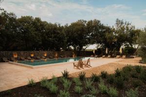 a swimming pool with two benches next to at Hotel Sant Ignasi in Ciutadella