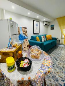 a living room with a blue couch and a table with food at Duba Holiday House in Palermo