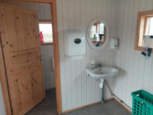 a bathroom with a sink and a mirror and a door at Fremstaver in Blaskogabyggo