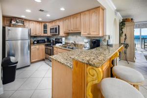 a kitchen with wooden cabinets and stainless steel appliances at Island Echos 3L in Fort Walton Beach