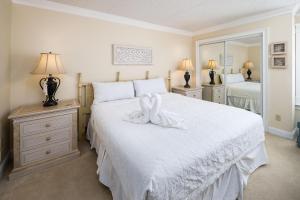 a bedroom with a white bed with a white towel on it at Island Echos 3L in Fort Walton Beach +37 photos