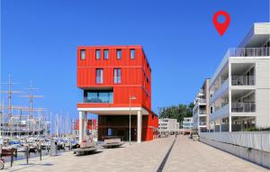 a red building next to a marina with boats at Priwallpromenade 23, Whg 9 in Priwall