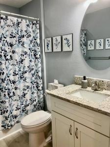 a bathroom with a toilet and a sink and a shower curtain at Brand New, Peaceful, and Dogs Stay Free in Marion Oaks