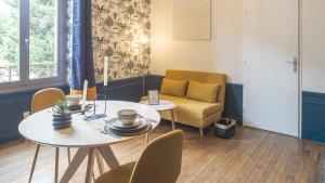 a living room with a table and a chair at BonAppart 12 - Charme Napoléonien & Confort in Troyes