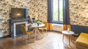 a living room with two tables and a fireplace at BonAppart 12 - Charme Napoléonien & Confort in Troyes