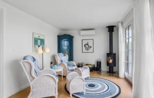 a living room with wicker chairs and a fireplace at 3 Bedroom Amazing Home In Svendborg in Svendborg