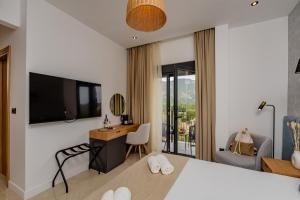 a bedroom with a bed and a desk and a tv at Hotel AQUILO in Petrovac na Moru