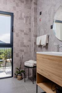 a bathroom with a tub and a sink and a window at Hotel AQUILO in Petrovac na Moru